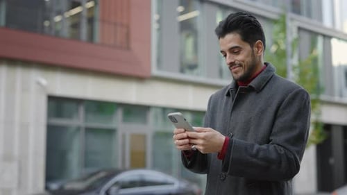 Handsome Man Using Smartphone in Urban Setting
