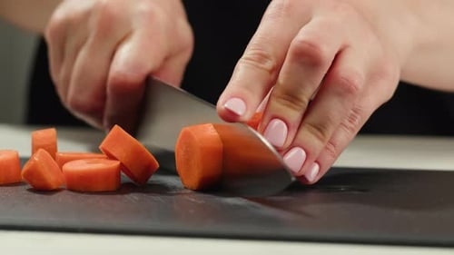 Woman Prepares Healthy Meal by Slicing Carrots