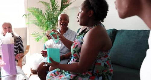 Women Gather Indoors for a Party, Opening Gifts