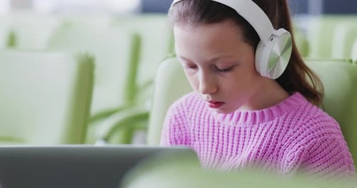 Girl Using Laptop with Headphones Indoors