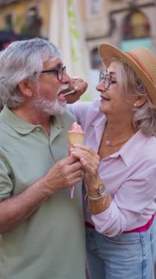 Cariñosa pareja mayor que comparte y come helado
