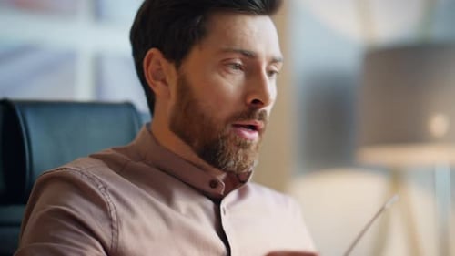 Thoughtful man rubbing head sitting in chair indoor