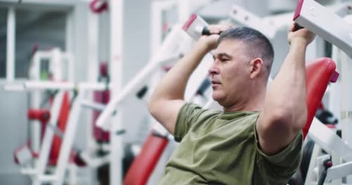 Man Using Shoulder Press Machine in Gym