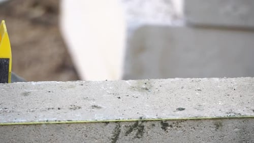 Industrial Worker Building Exterior Walls Using Hammer and Level for Laying Bricks in Cement