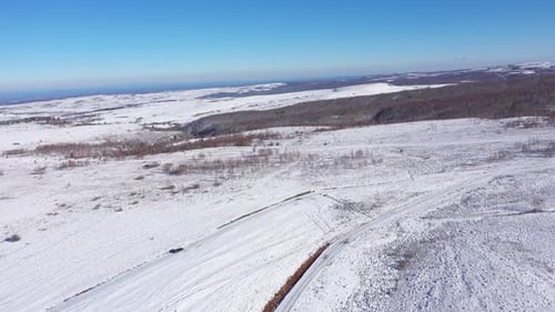 Aerial View of Car Driving on a Winter Road. Winter Countryside Landscape