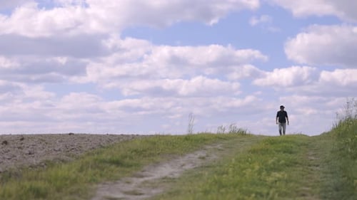 Man Walking on Lush Green Field