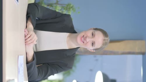 Woman Communicating at Table in a Bright Office
