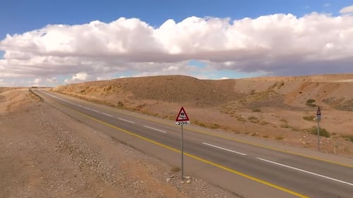Empty Desert highway mountain road with Blue cloudy sky