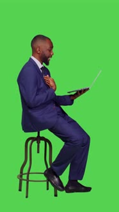 Man in Suit Talking on Laptop on Green Screen