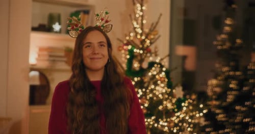 Young Woman Excitedly Juggling Christmas Gift Indoors