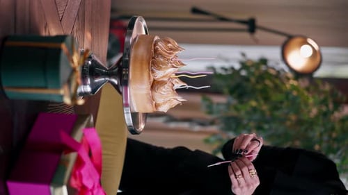 vertical video close-up of delicious appetizing cake hand puts candle during birthday celebration