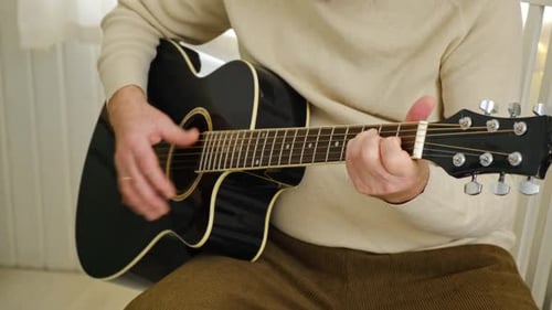 Senior Man is Playing Guitar Elderly Man Sitting on the Sofa and Playing Guitar Portrait of a