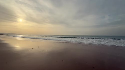 Static view of beach and sea under a sunset cloudy sky