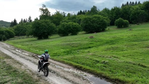 Aerial Shot of a Motocross Rider on a Journey on a Dirt and Dusty Country Road Driving Fast and
