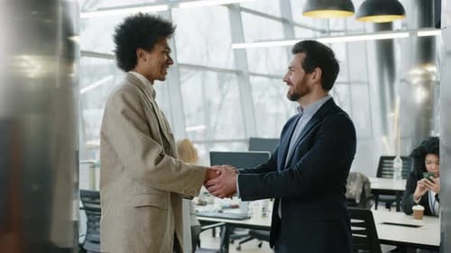 Two Businessmen Shake Hands in Modern Office