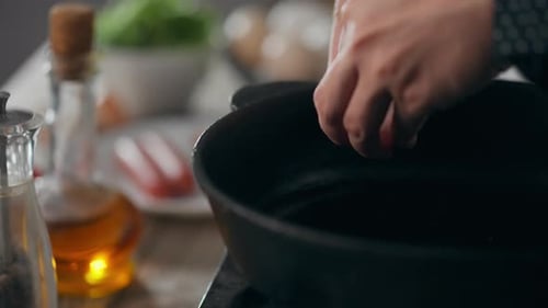 Casserole. Parent responsable d'enfants en uniforme de chef heureux de faire frire des œufs dans une poêle à frire dans la cuisine de la maison