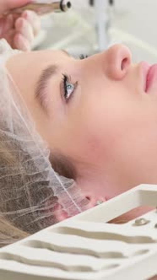 A Dermatologist Examines the Skin on a Young Woman's Face A Beautician at Work in His Office