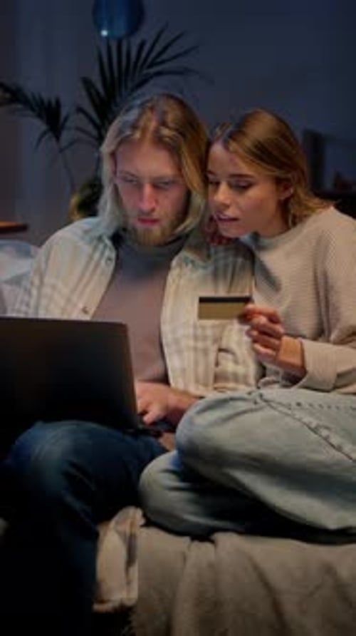 Couple Excitedly Shops Online in their Home at Night