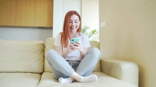Woman Receives Good News on Smartphone and Celebrates