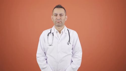 Doctor Speaking in White Coat on Orange Background