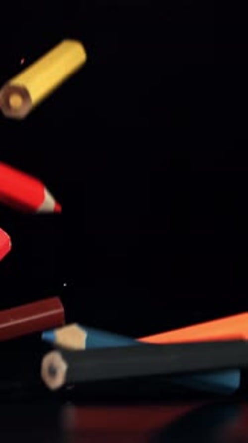 Colored Pencils Falling on a Table on a Black Background Filmed on a Highspeed Camera at 1000 Fps