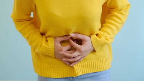 Woman Holding Her Stomach in Discomfort