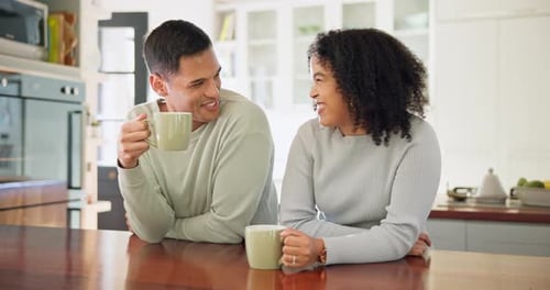 Laughing Couple Drinking Coffee in a Modern Kitchen