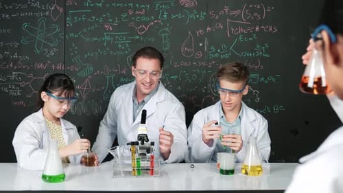 Kids Do Experiment With Teacher in Science Classroom