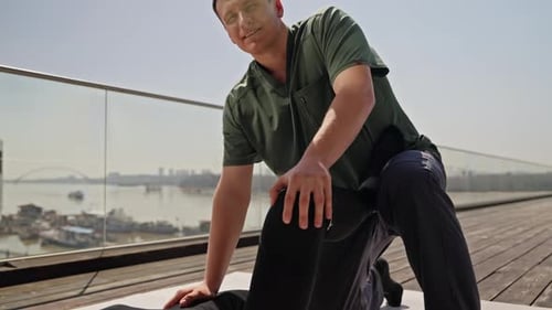 Man Massaging Another Man's Leg on Rooftop