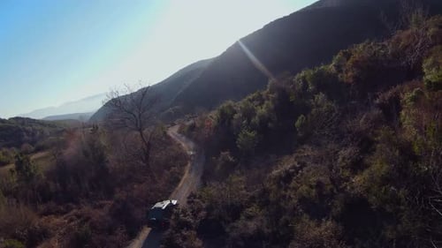 Off road car driving fast on gravel under hill track