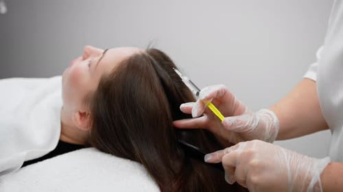 A beautician makes injections into the scalp for hair growth Mesotherapy for hair growth