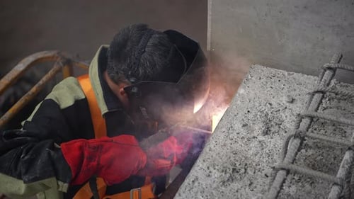 Bauarbeiter schweißt Metallverstärkung vor Ort