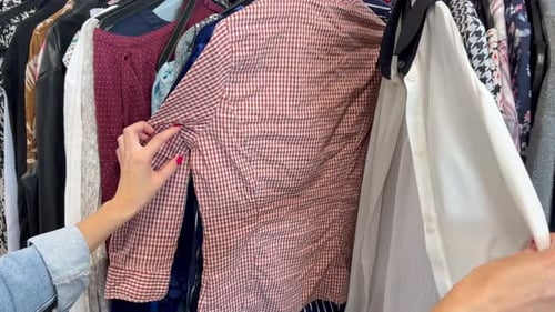 Closeup of a Woman in a Store Looking at a Sale of Clothes Sale of Promotional Clothing