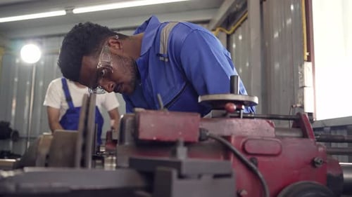 Diversity mechanic worke using metal lathe machine operate tool in the factory