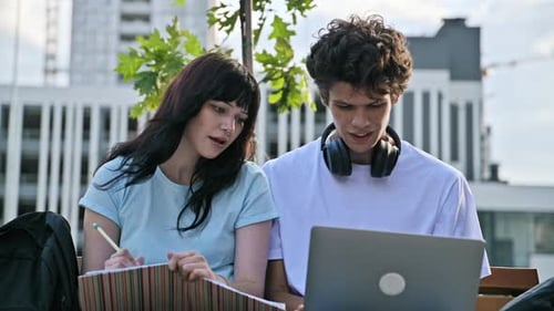 Students Teenage Male and Female Studying Together Outdoors Using Laptop Notebooks