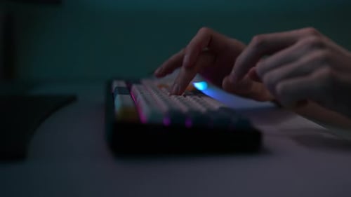 Closeup Side View of Unrecognizable Hacker Male Typing on Wireless RGB Mechanical Keyboard with
