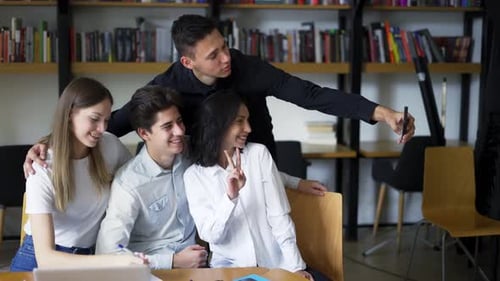 European Students Group of Four Take Selfie in the College or University Library