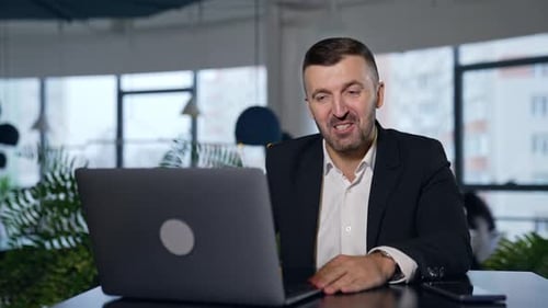 Smiling Man on Video Call in Office