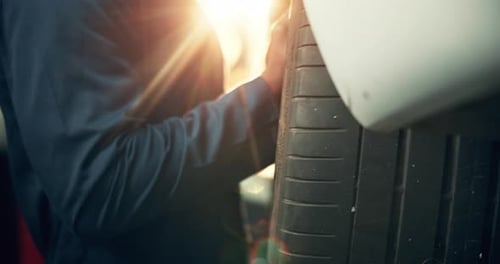 Mechanic Inspecting Tire in a Garage
