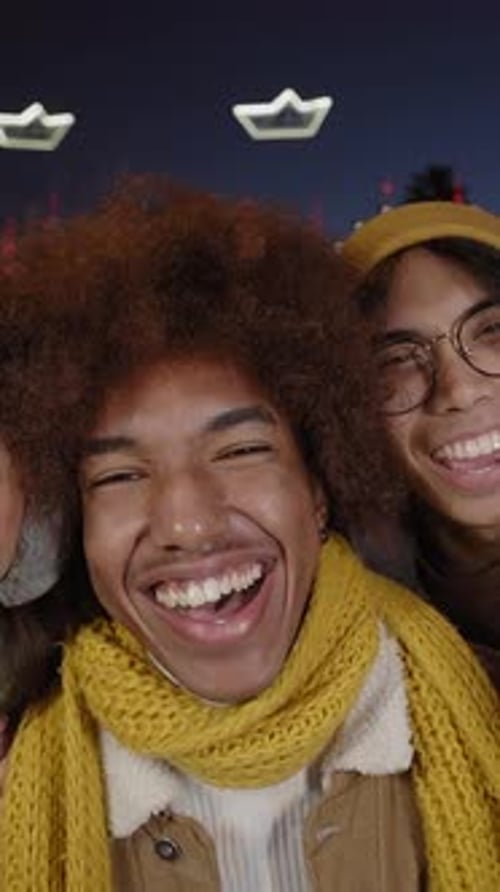 Three Friends Smiling for a Selfie at Night