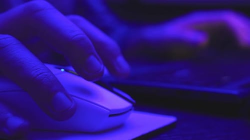 Homem navegando na Internet enquanto clica no mouse e digita no teclado