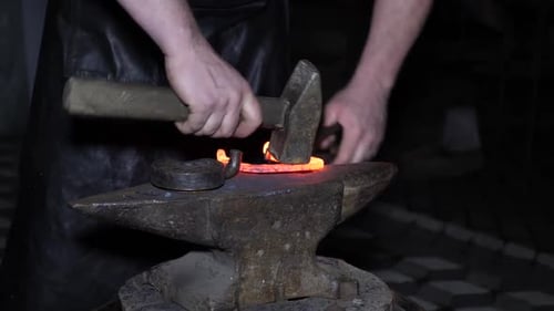 Blacksmith Forging Hot Metal on Anvil with Hammer
