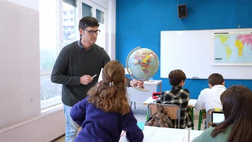 Geography Teacher Showing World Globe to Students in Classroom