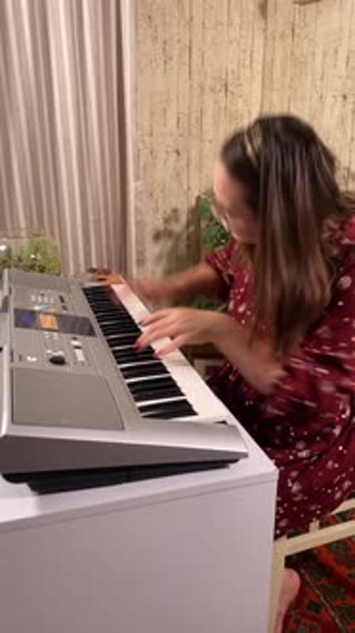 Woman Plays Electronic Keyboard at Home