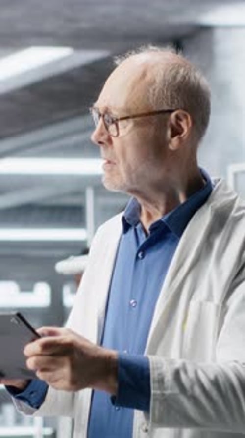 Vertical Video Male Researcher Focuses on Experiment Data in a Research Study
