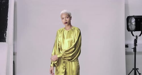 Fashionable Woman Posing in a Studio with Satin Outfit