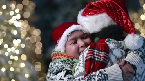 Close Up of Young Boy in Christmas Hat Hugging Mother African American Woman