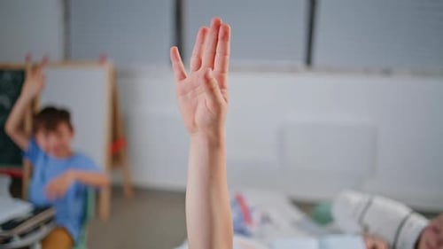 Children Raising Hands in Classroom Setting