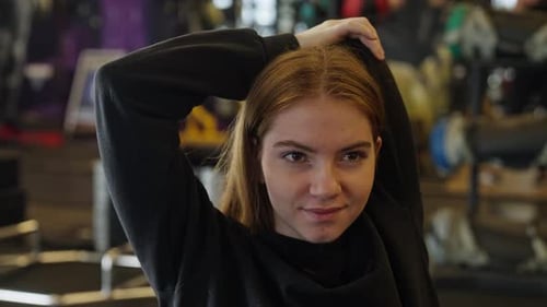 Young Woman Stretching Arms In Gym