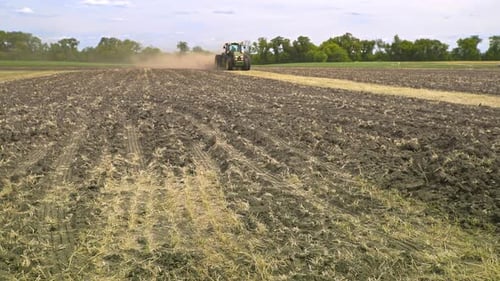 Agricultural Tractor on Field. Farming Tractor Working on Agricultural Field. Farming Machinery